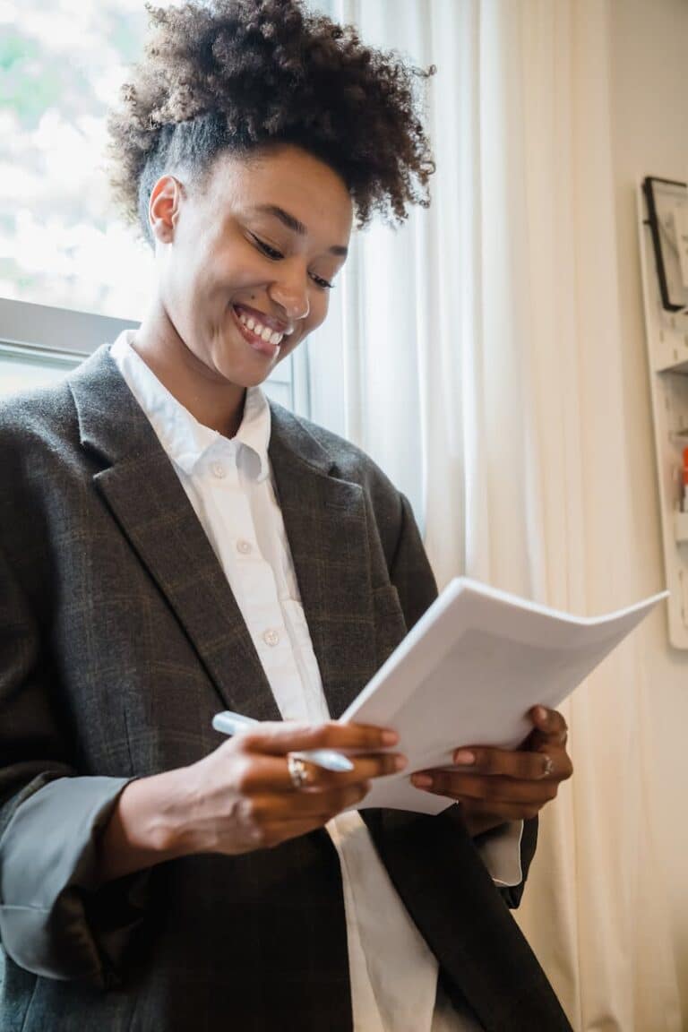 Confident businesswoman reviewing documents in a bright office setting.