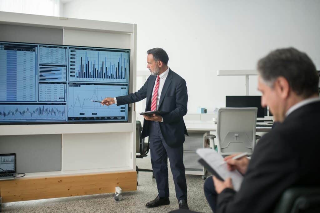 Professional conducts data analysis presentation in a modern office setting.