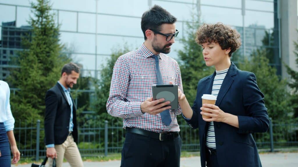 Two business people discussing a tablet outdoors